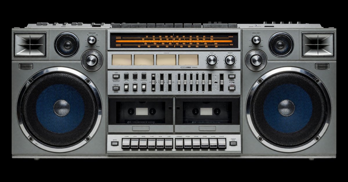 Boomjack: a big silver boombox with two blue woofers and twin cassette decks, on black.